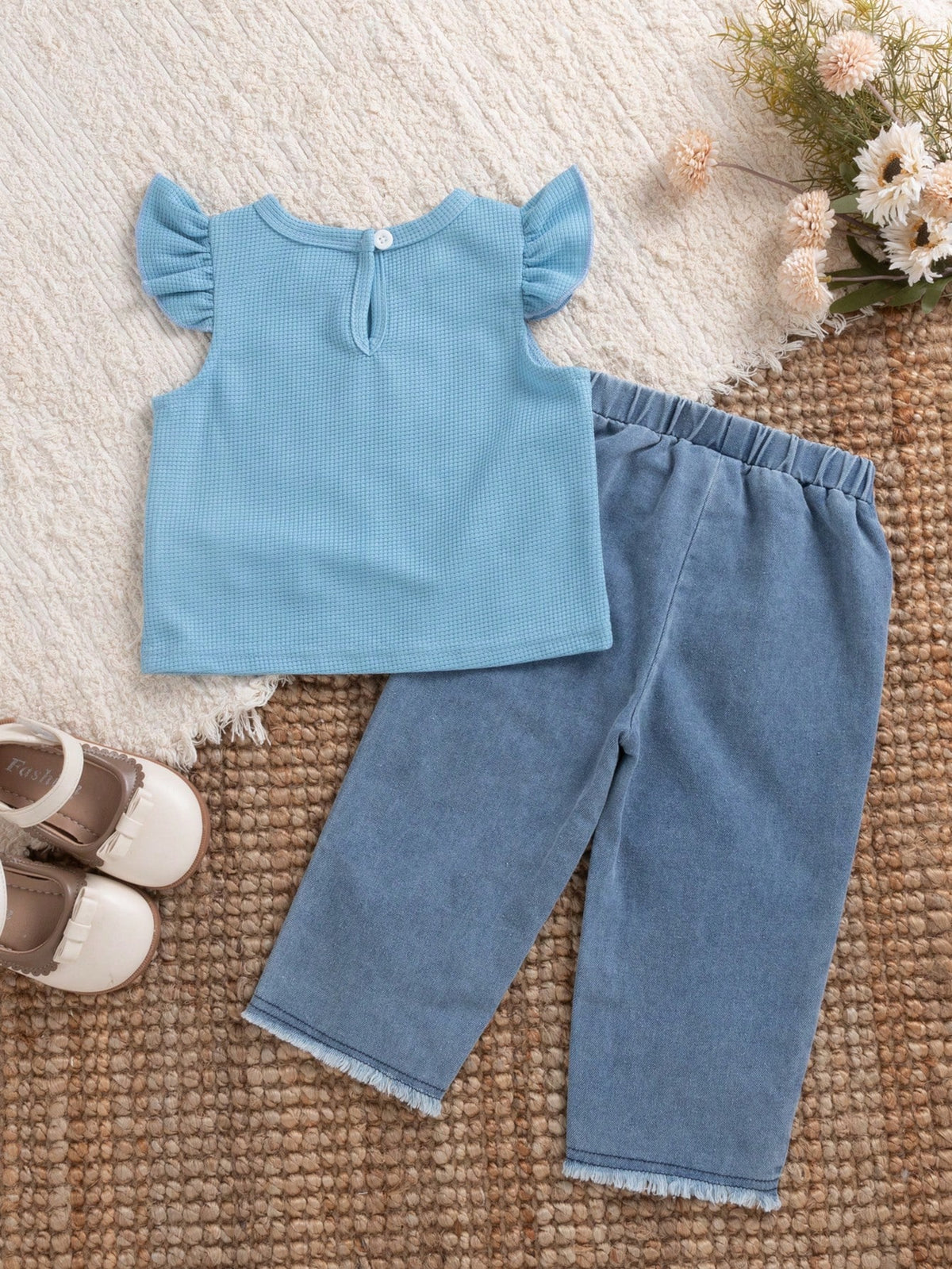 Conjunto celeste para bebé con blusa de textura gofre y pantalón azul de mezclilla, vista posterior.