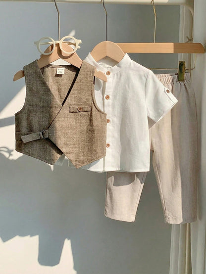 Conjunto beige para bebé con chaleco asimétrico, camisa blanca de manga corta y pantalón largo, vista frontal