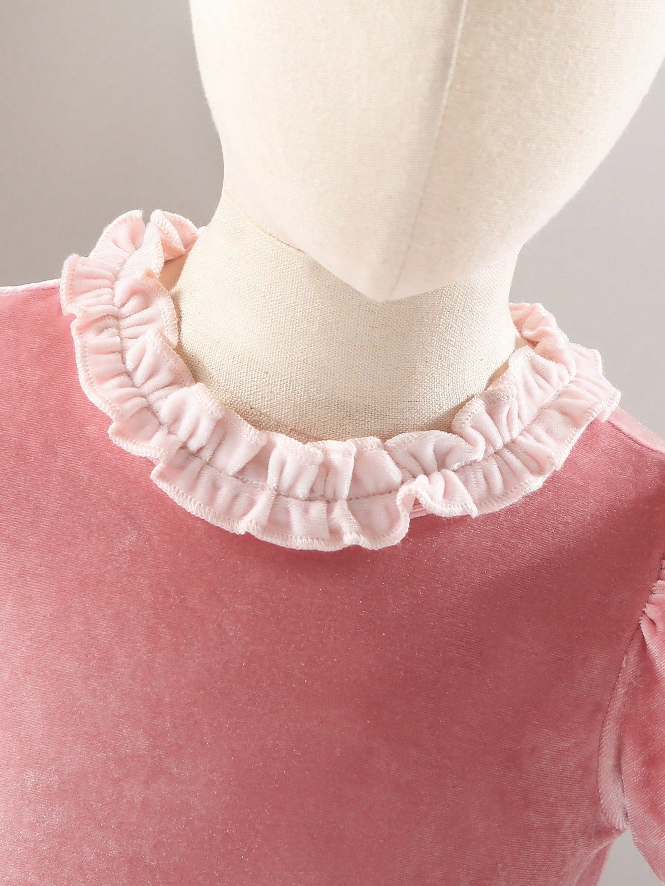 Prenda rosa vestido para bebe detalle del cuello con volantes y acabado aterciopelado