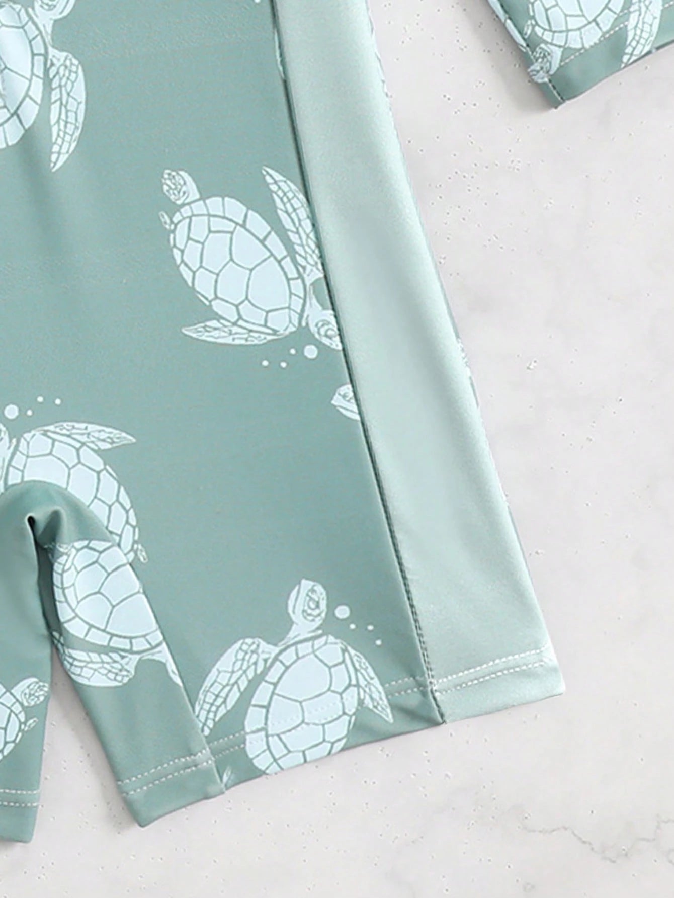 Prenda verde traje de baño para bebe con detalle de costuras y estampado