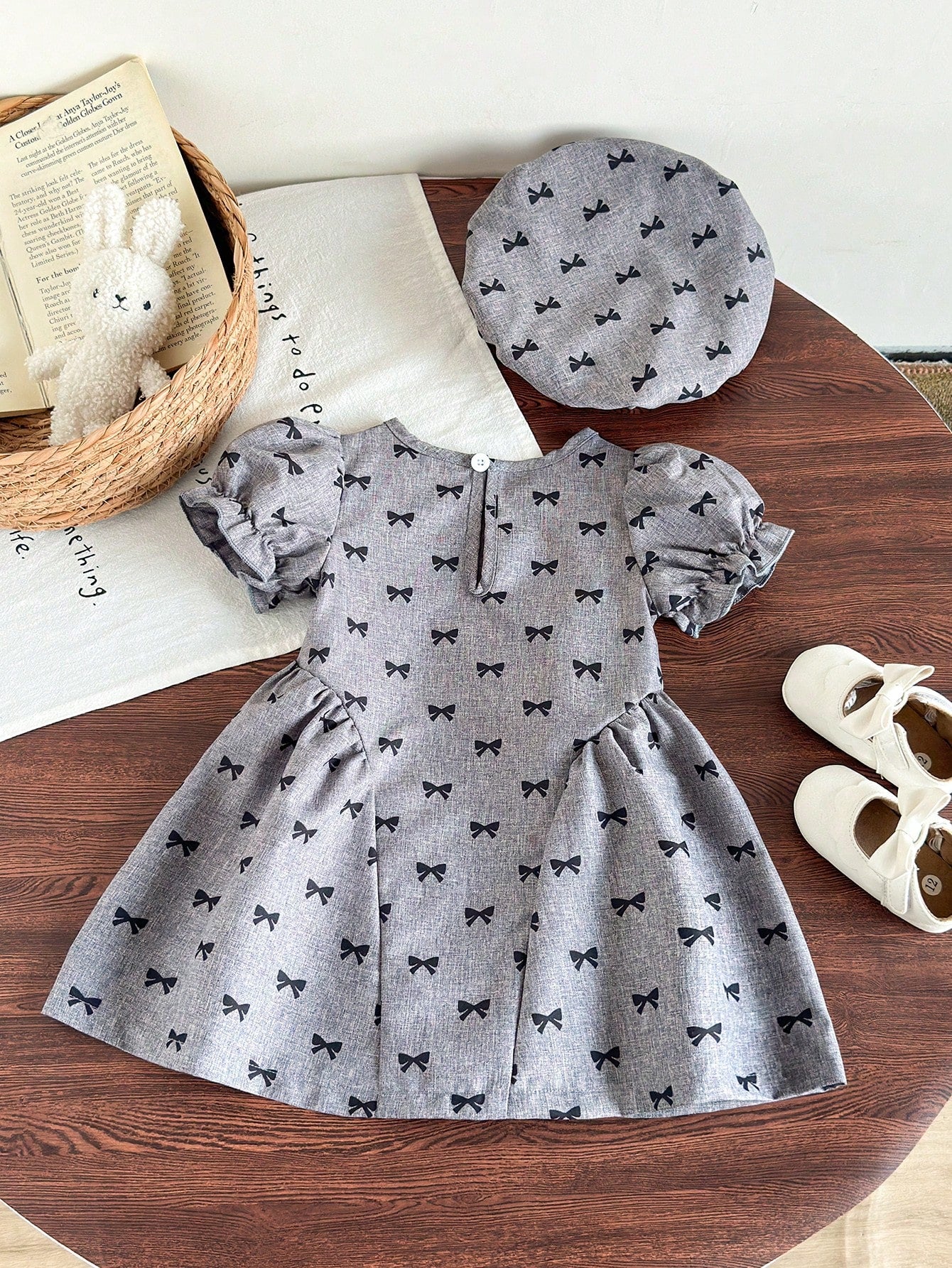 Prenda gris vestido para bebe con lazos negros vista trasera