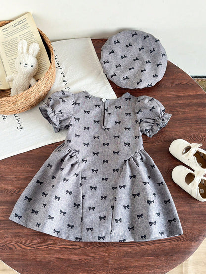 Prenda gris vestido para bebe con lazos negros vista trasera