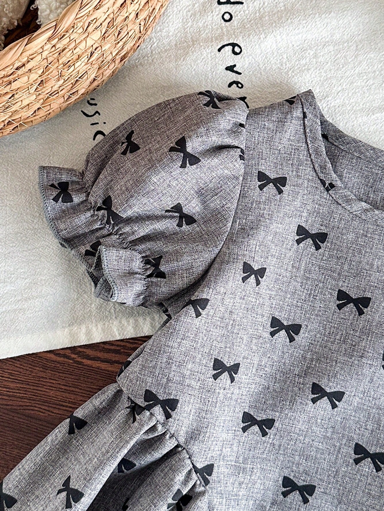 Prenda gris vestido para bebe detalle de manga abullonada y estampado de lazos