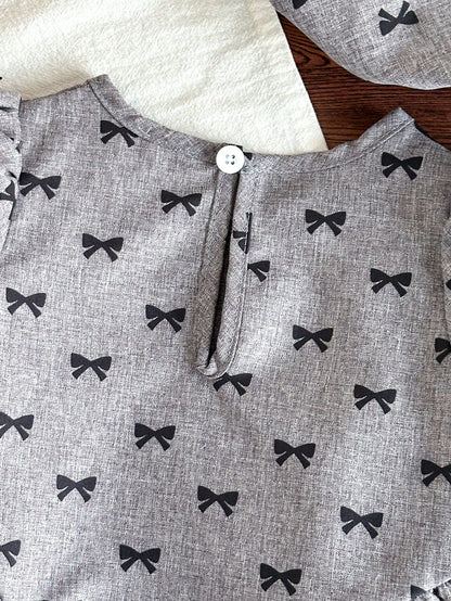 Prenda gris vestido para bebe detalle de cierre posterior con botón