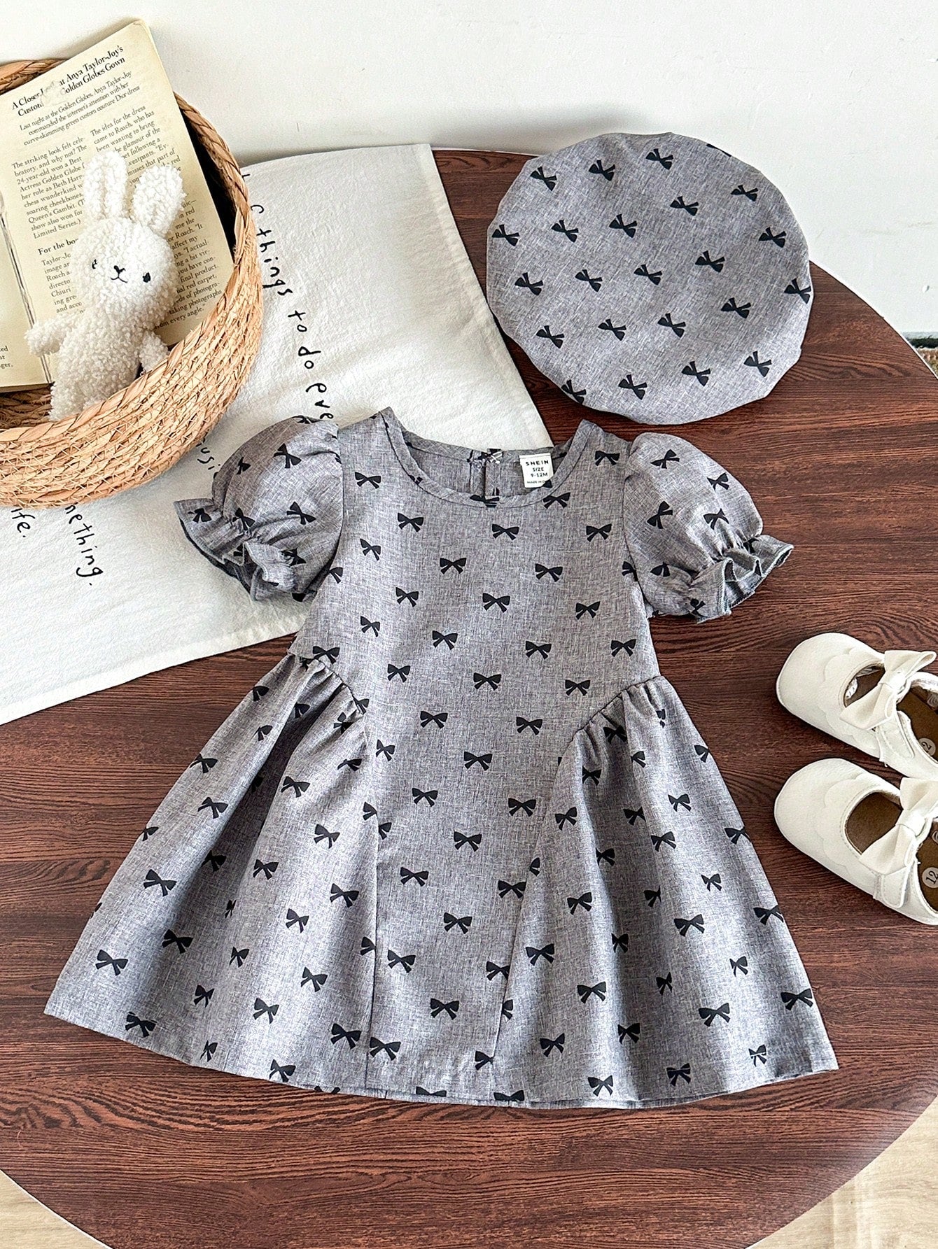 Prenda gris vestido para bebe con lazos negros y boina vista frontal