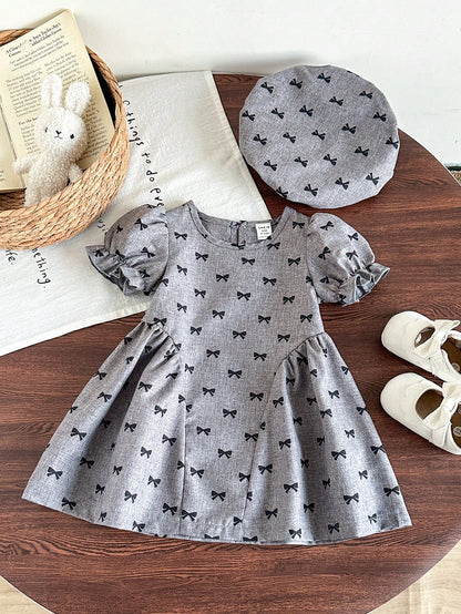 Prenda gris vestido para bebe con lazos negros y boina vista frontal