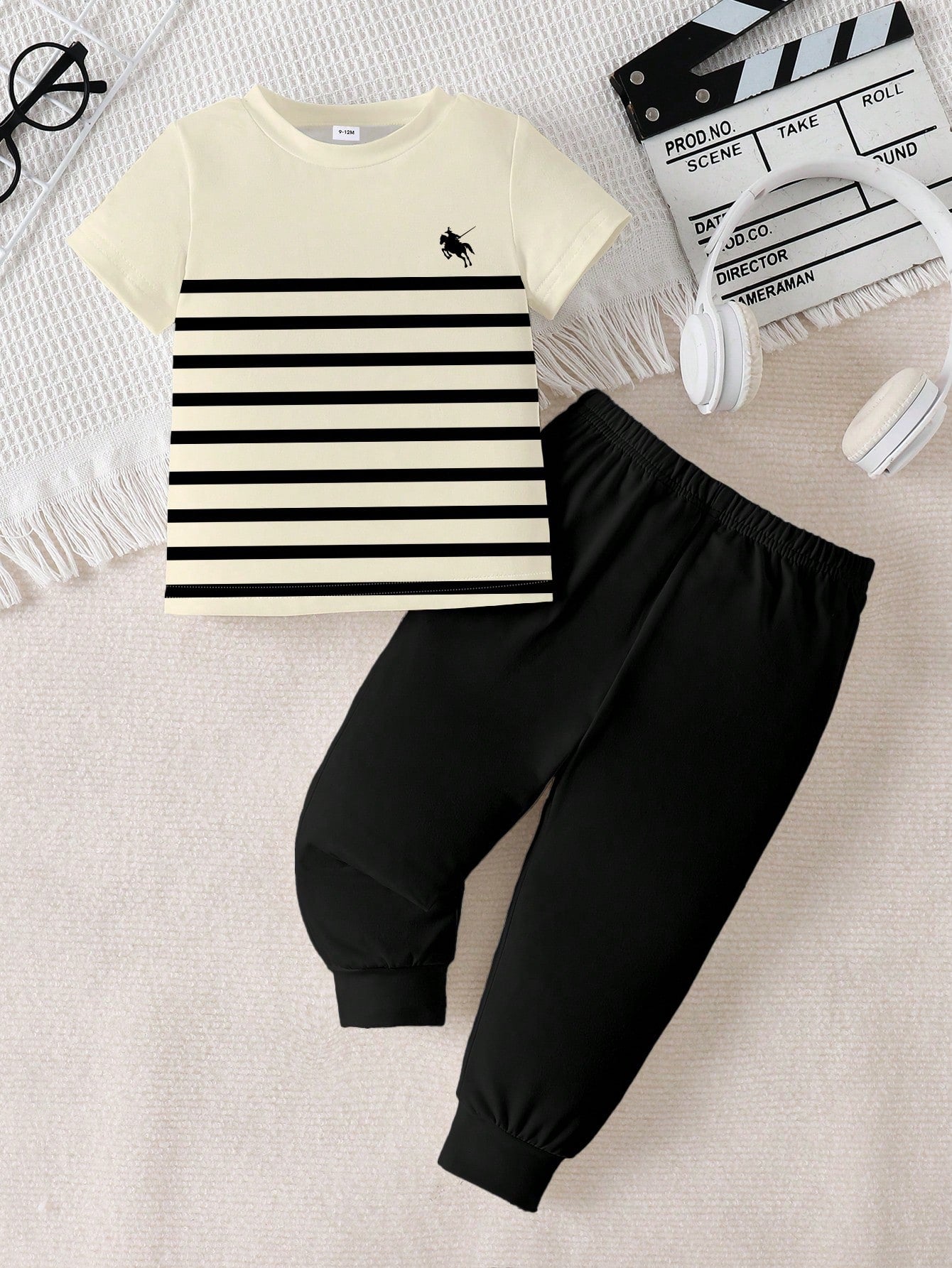 Prenda crema conjunto para bebe con camiseta rayada y pantalón negro vista frontal
