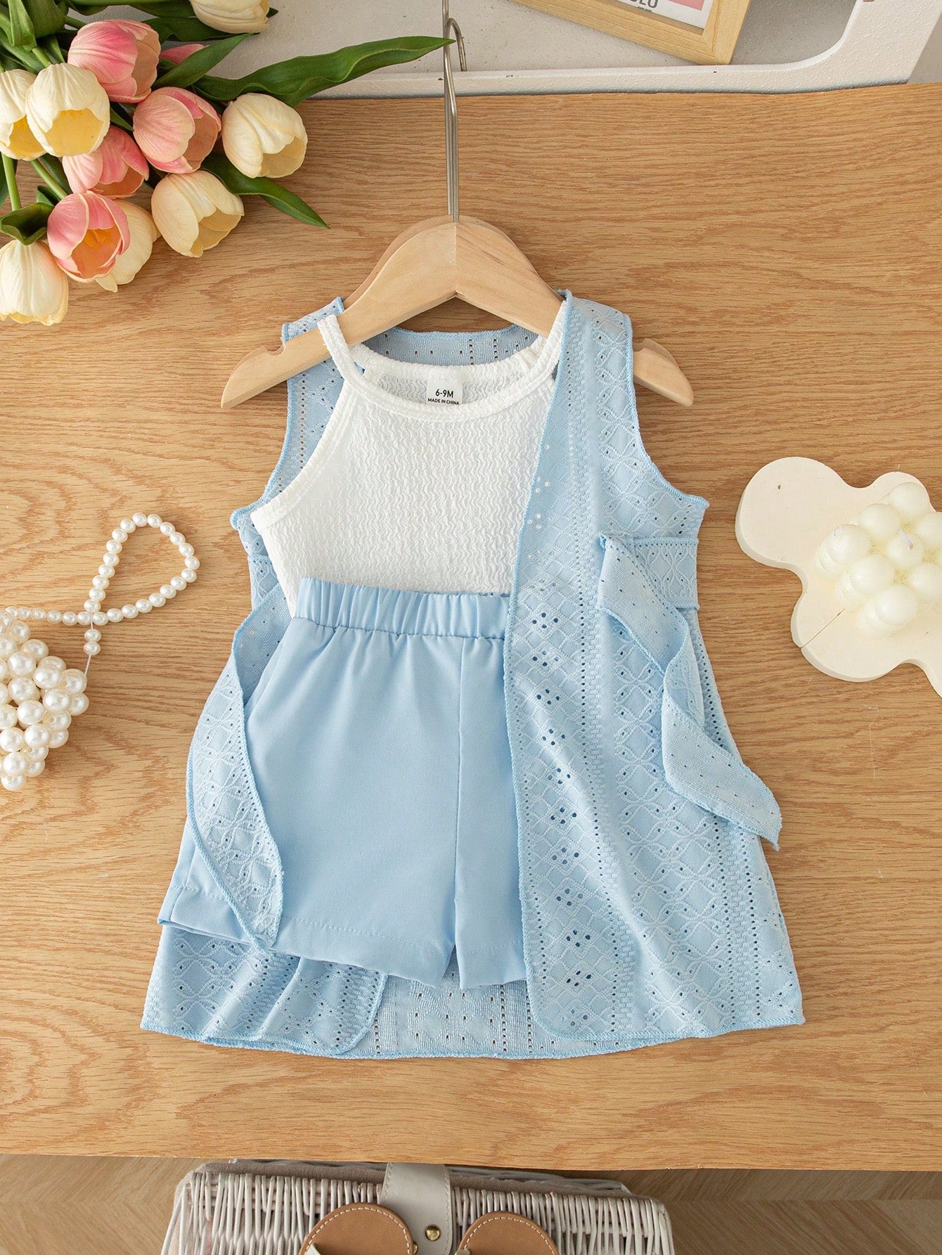 Prenda azul conjunto para bebe con chaleco calado vista frontal