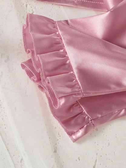 Prenda rosa pijama de satén para bebe con detalle de volantes en el pantalón