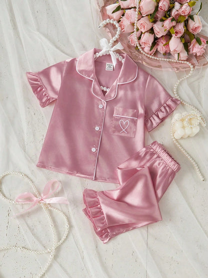 Prenda rosa pijama de satén para bebe con corazón bordado vista frontal