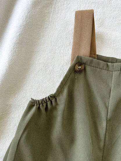 Prenda verde overol para bebe detalle de tirantes y botones
