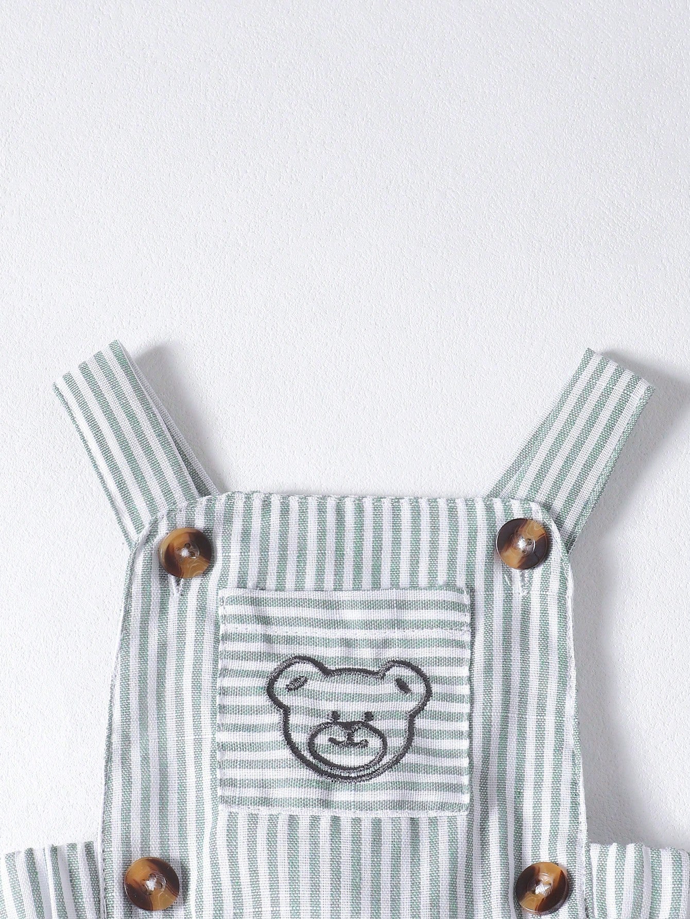 Prenda verde peto rayado para bebe con bordado de osito detalle frontal