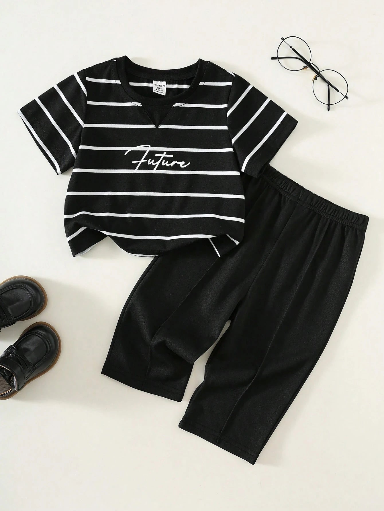 Prenda negra conjunto para bebe con camiseta a rayas vista frontal