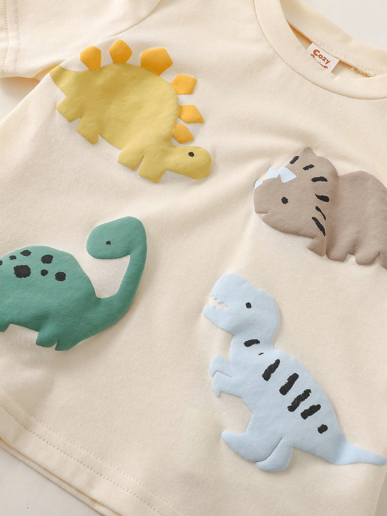 Prenda albaricoque conjunto para bebe detalle de camiseta con dinosaurios en relieve