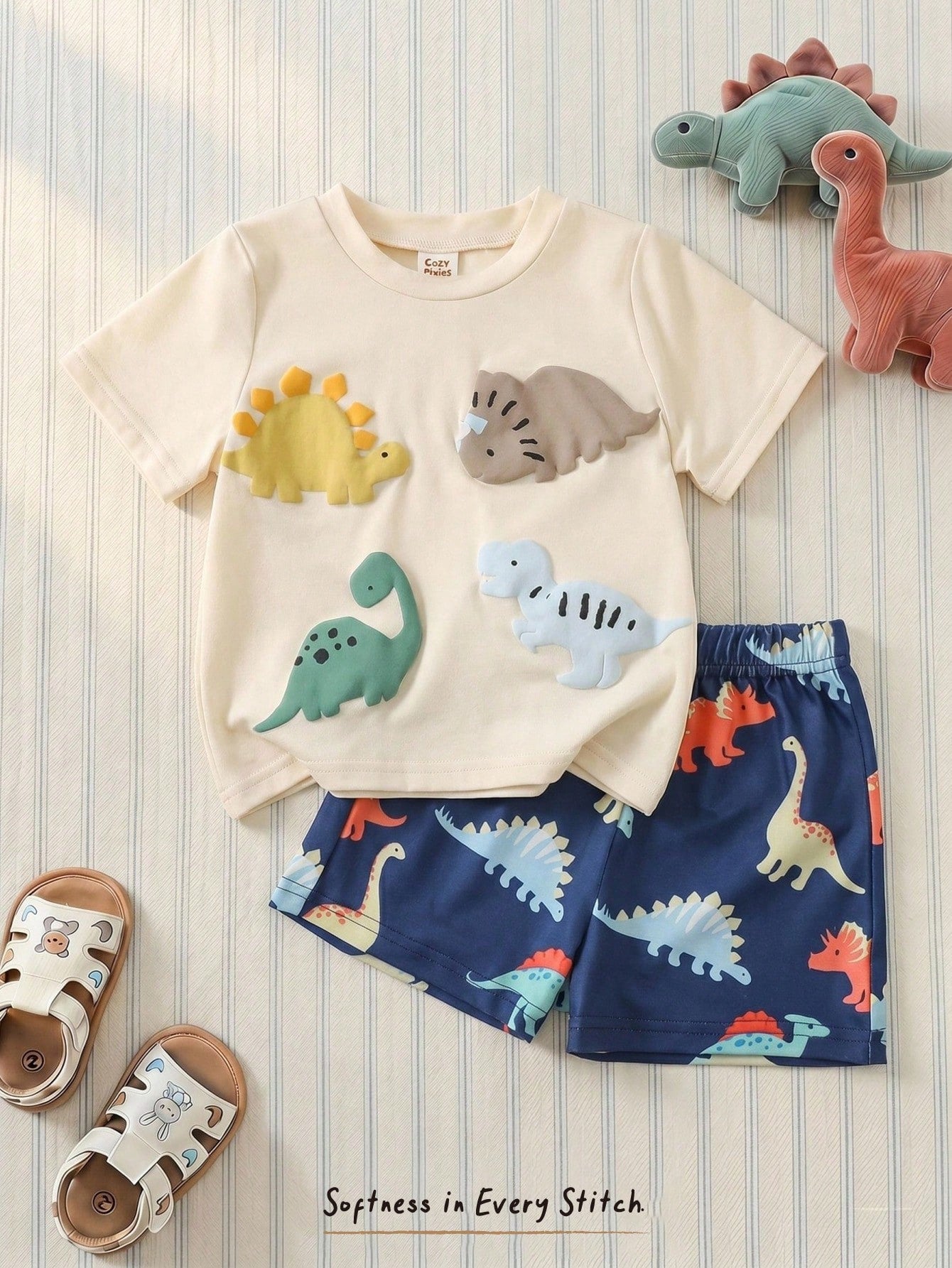Prenda albaricoque conjunto para bebe con dinosaurios y shorts azules vista frontal