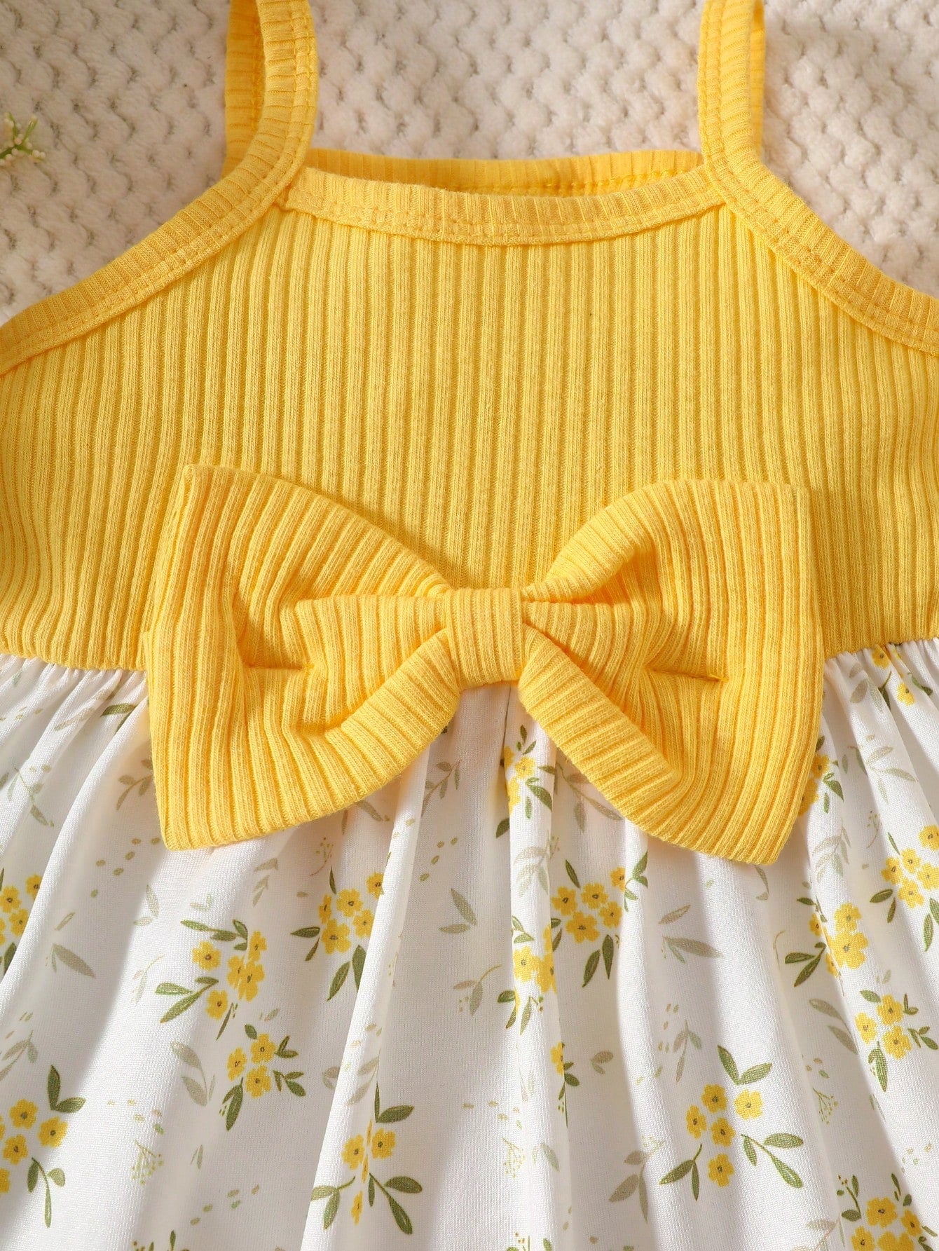 Prenda amarilla vestido para bebe con lazo delantero detalle del acabado