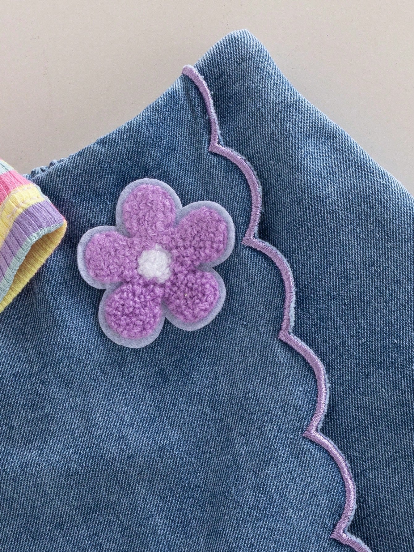 Prenda multicolor tipo conjunto para bebe con detalle de flor aplicada y borde festoneado