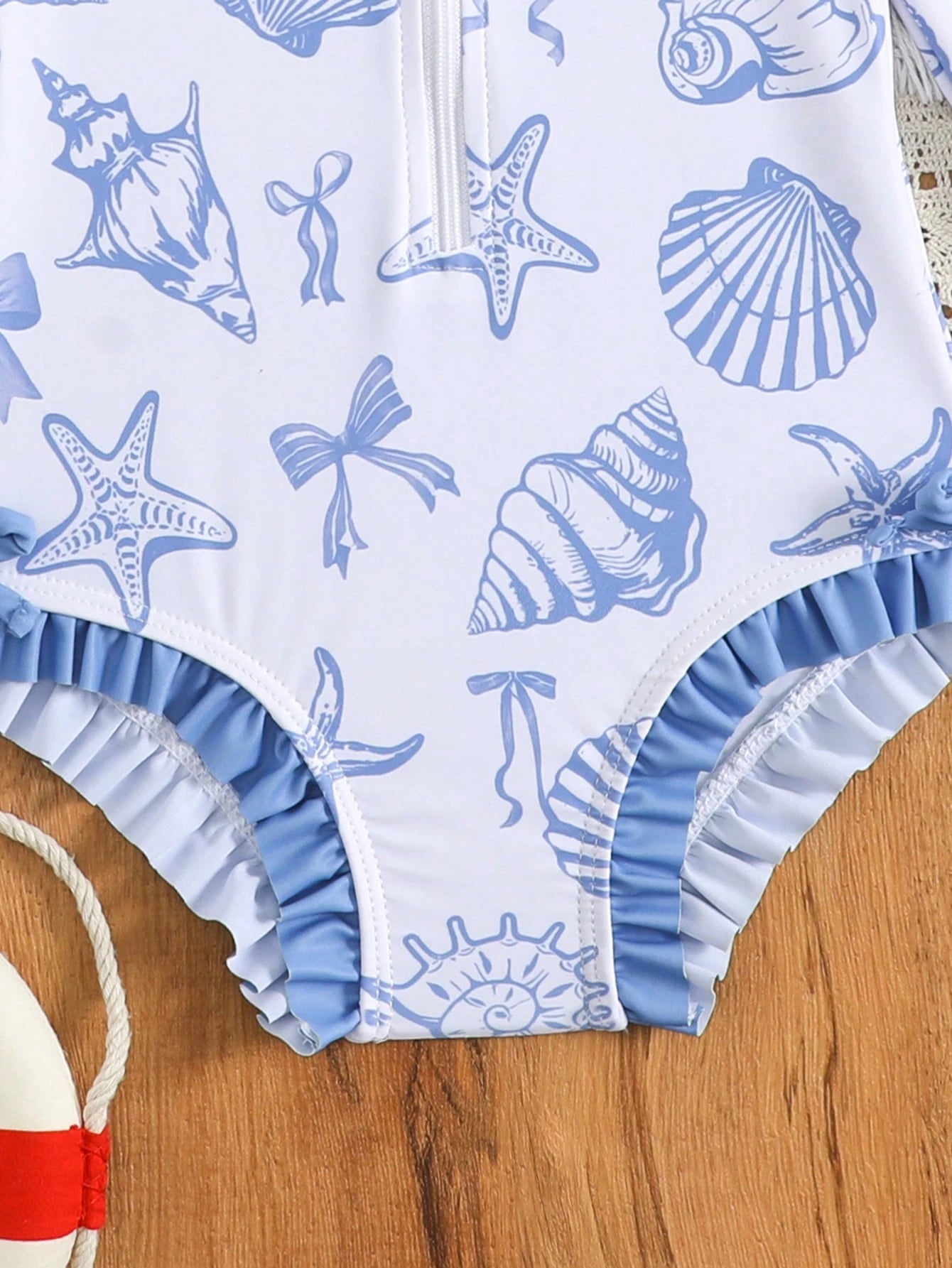Prenda azul traje de baño para bebe con detalle de volantes y estampado