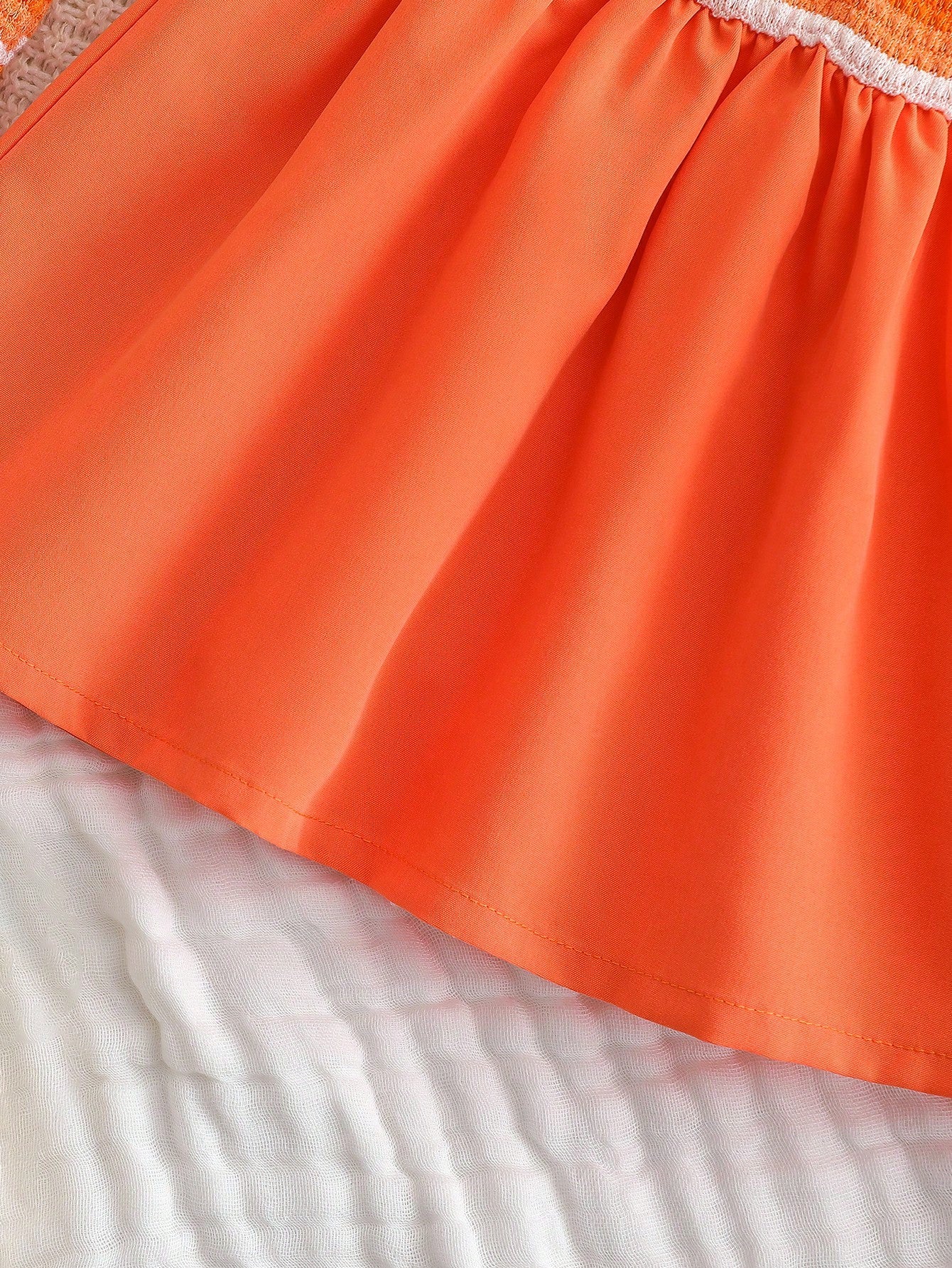 Prenda naranja vestido para bebe con falda amplia detalle del acabado