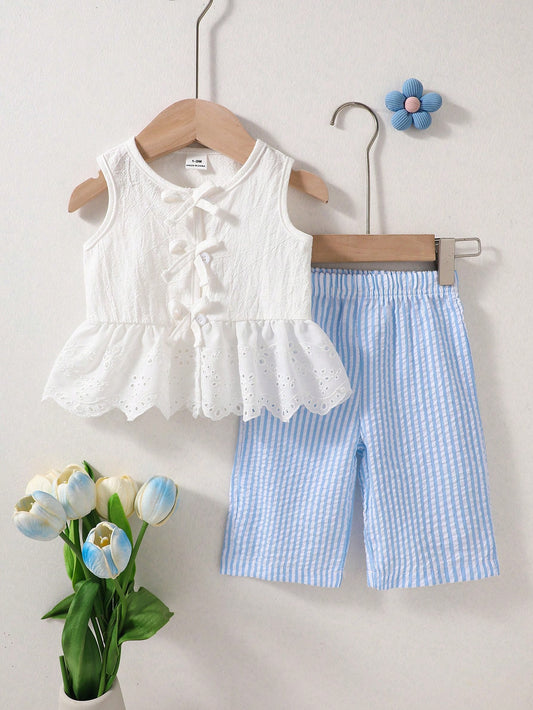 Conjunto blanco y azul para bebe con blusa de volantes bordados y pantalón de rayas, vista frontal.
