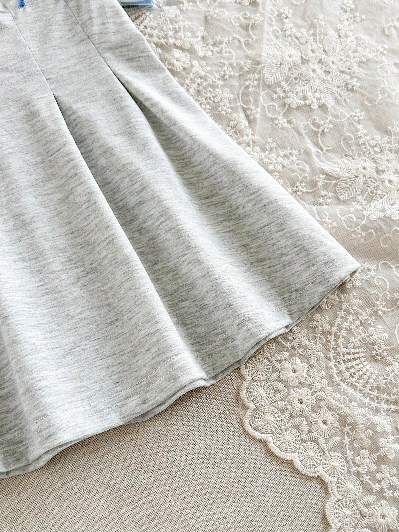 Prenda gris vestido para bebe con detalle de falda plisada y acabado inferior