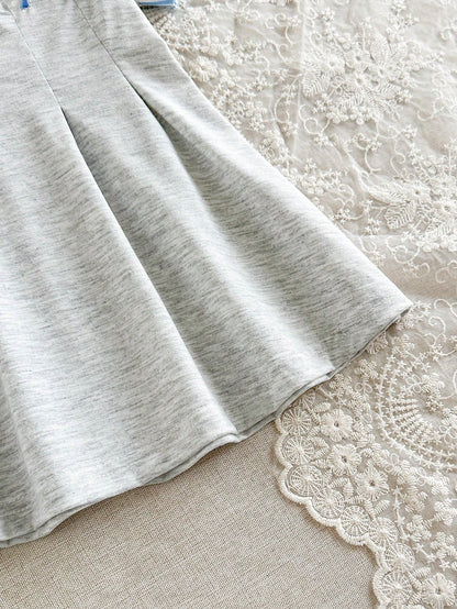 Prenda gris vestido para bebe con detalle de falda plisada y acabado inferior