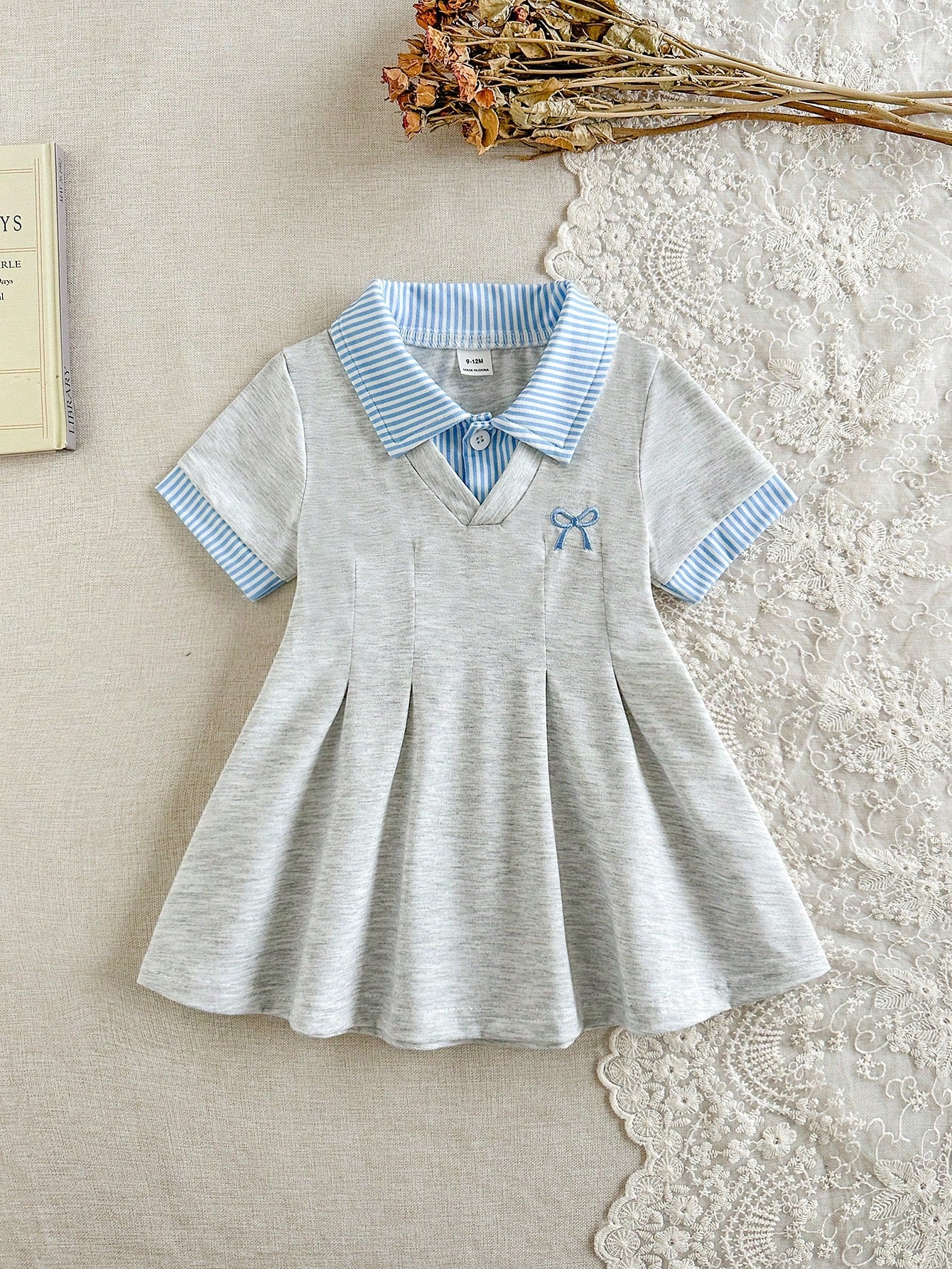 Prenda gris vestido para bebe con cuello rayado vista frontal
