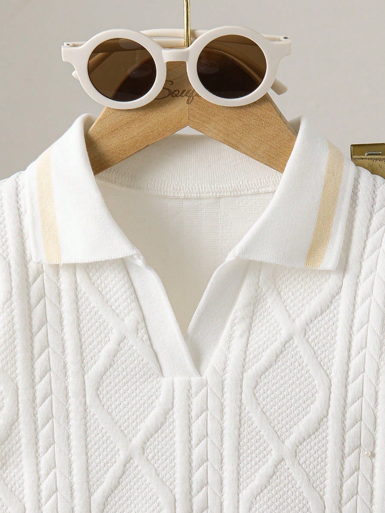 Prenda blanca conjunto para bebe con detalle de cuello polo y textura geométrica