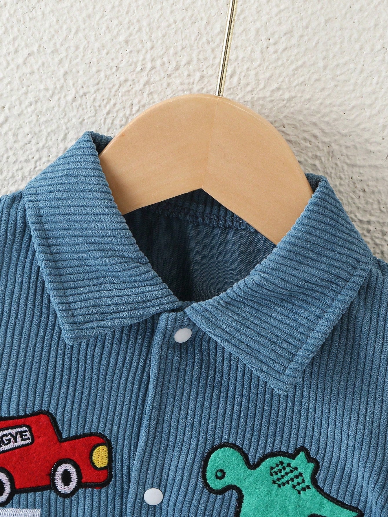 Prenda azul mameluco para bebe con cuello camisero detalle frontal