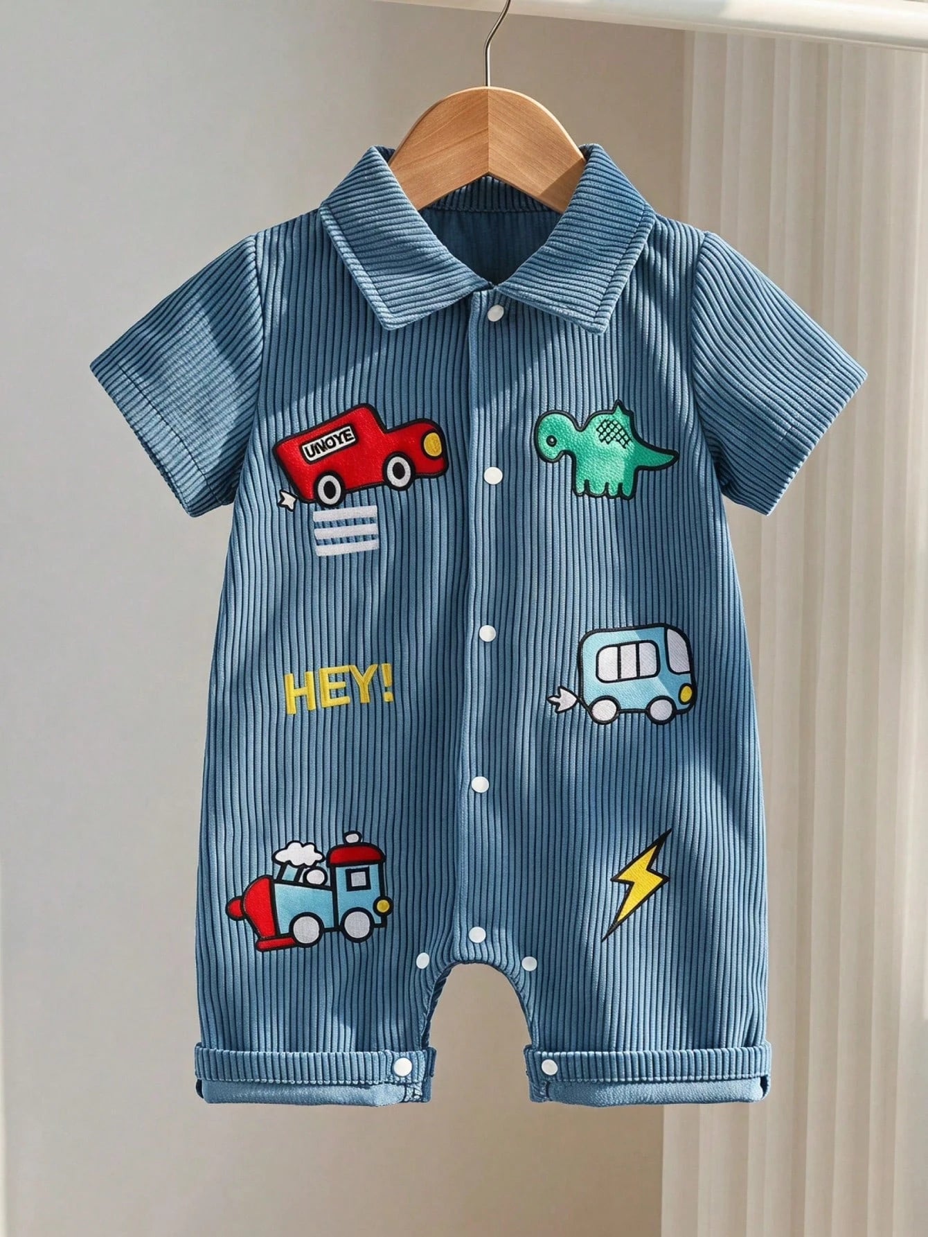 Prenda azul mameluco para bebe con coche y dinosaurio vista frontal