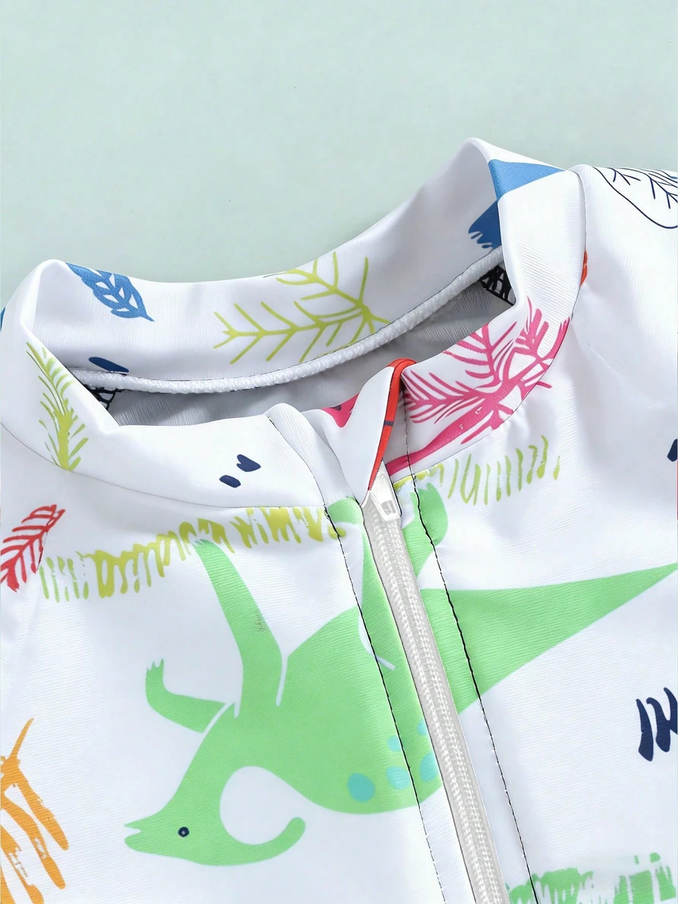 Prenda blanca traje de baño para bebe con cremallera frontal detalle superior