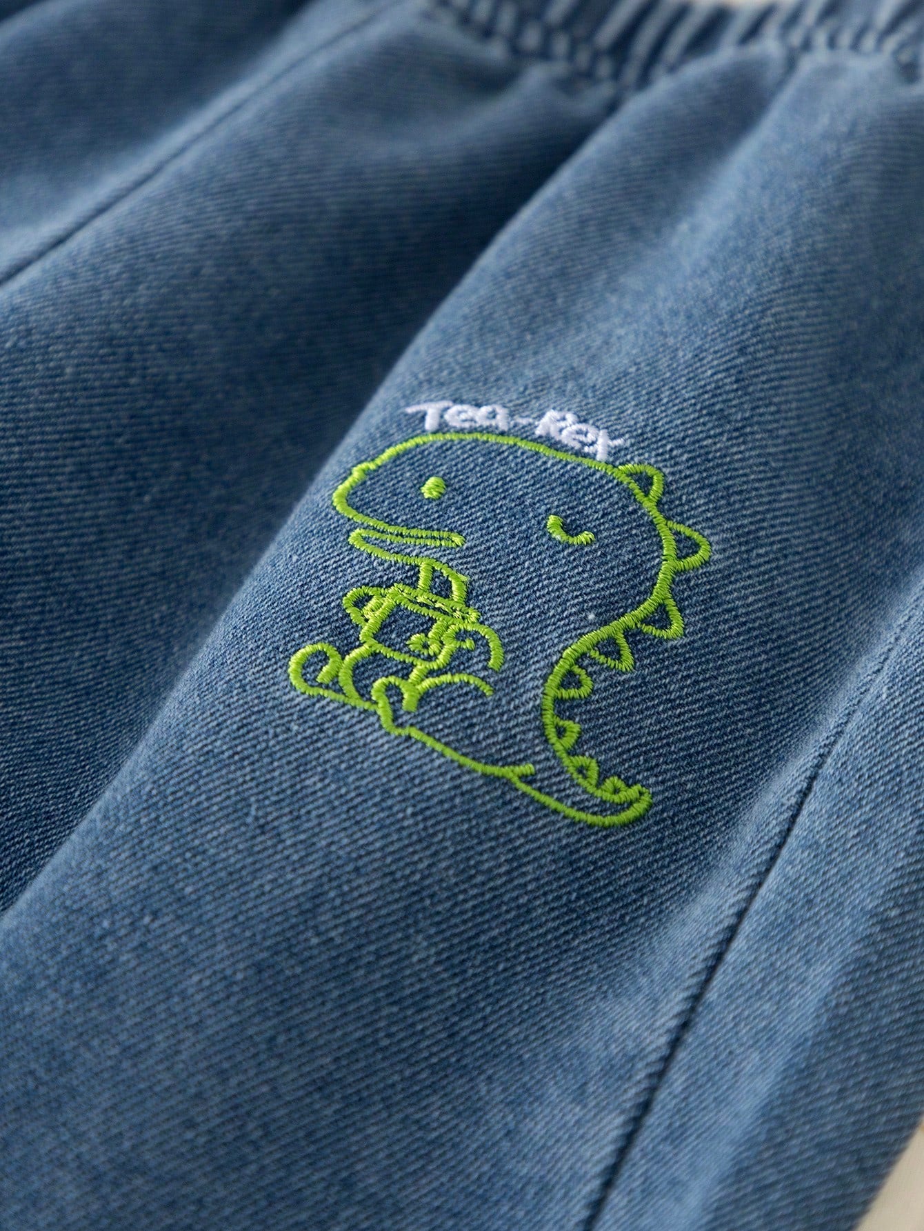 Prenda azul pantalón para bebe con detalle de dinosaurio bordado