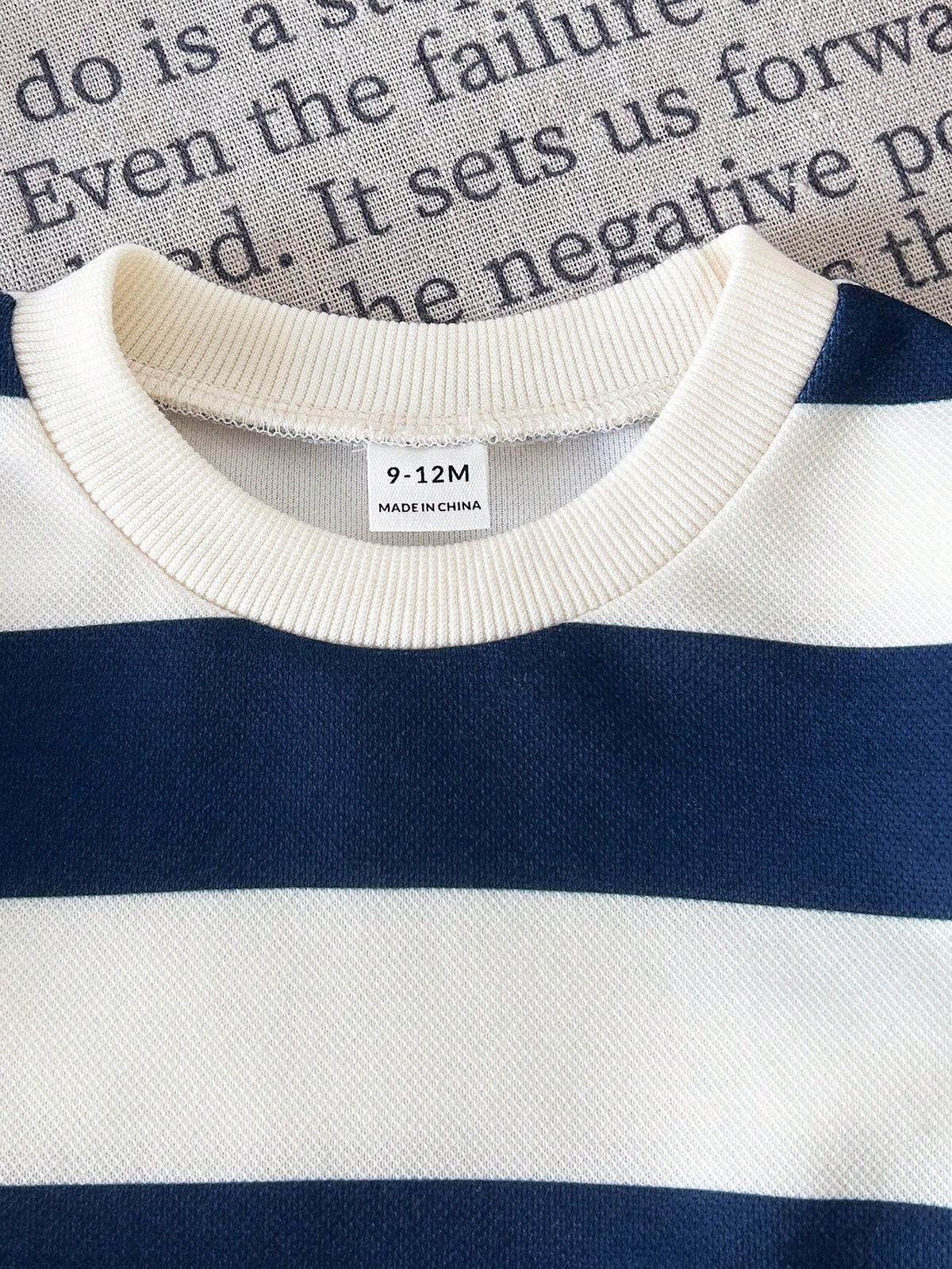 Prenda azul marino sudadera para bebe con detalle de rayas y cuello redondo

