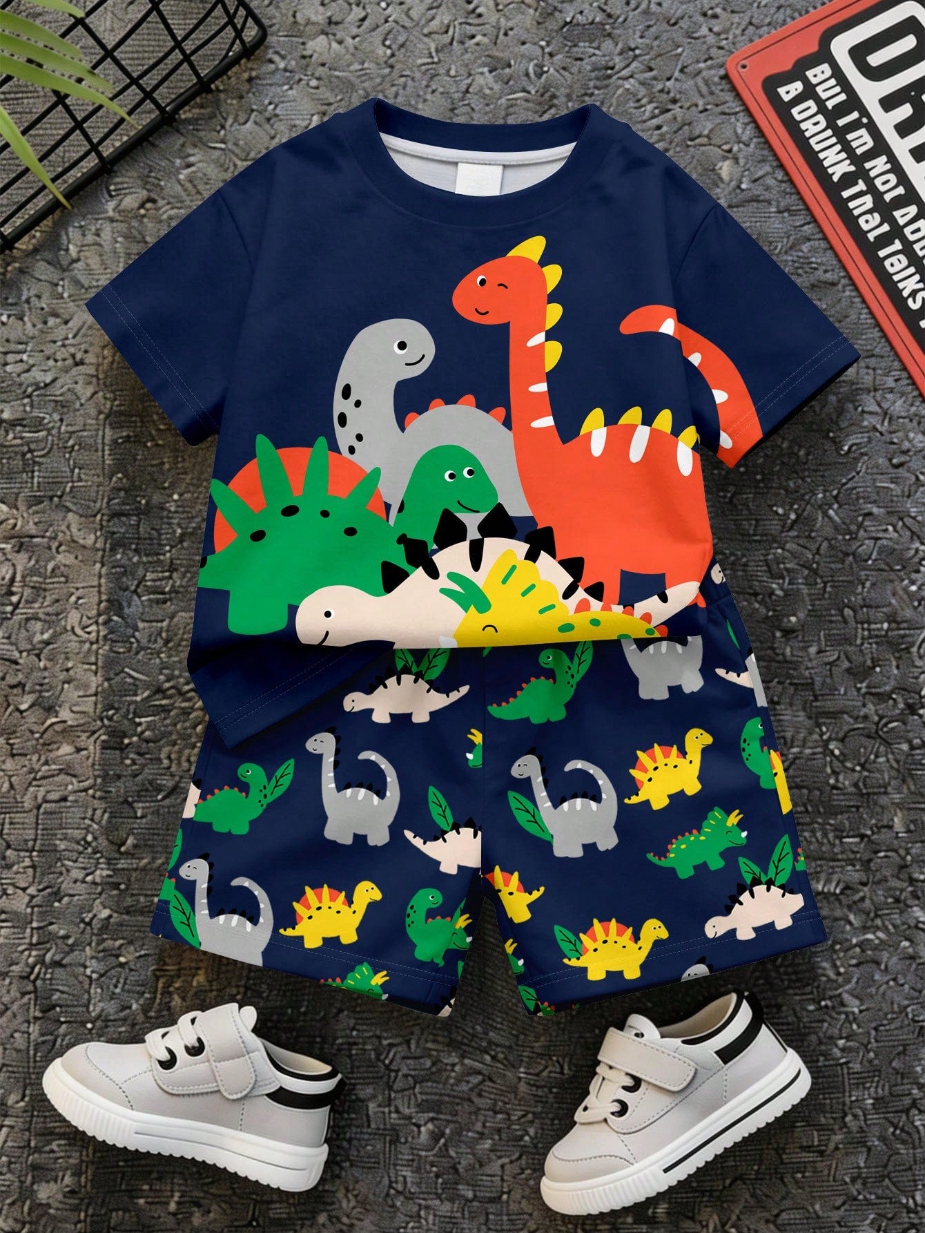 Prenda azul marino conjunto para bebe, vista frontal con estampado de dinosaurios coloridos