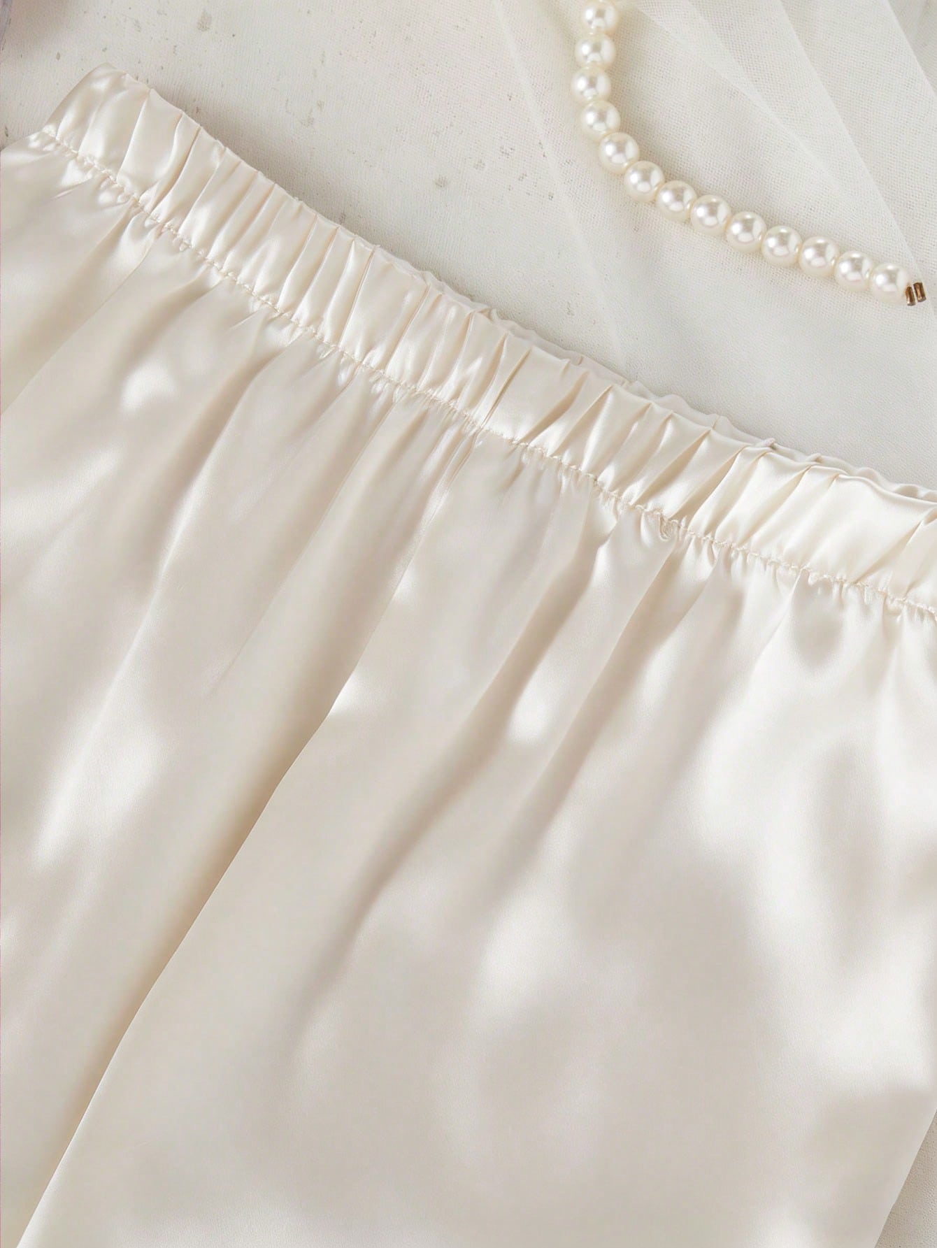 Prenda champán pijama para bebe con detalle de pantalón satinado y cintura elástica