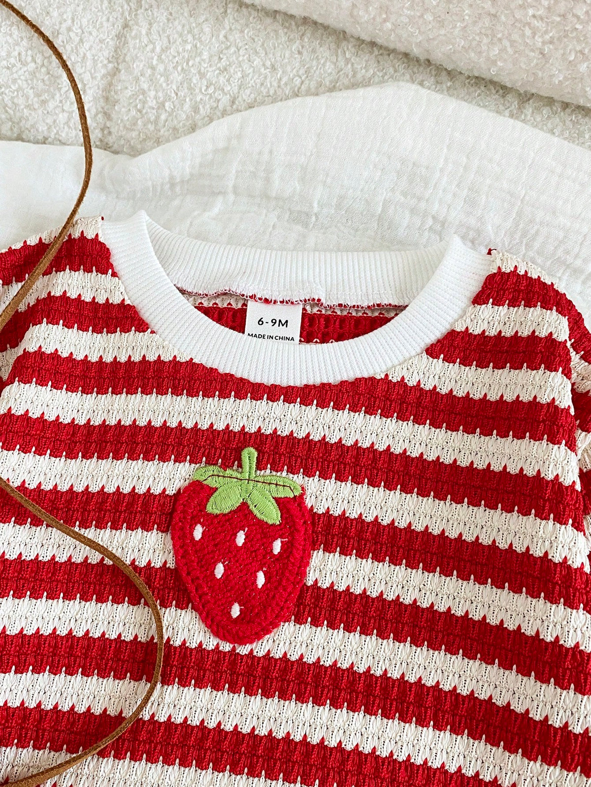 Prenda roja y blanca conjunto para bebe con aplicación de fresa en relieve