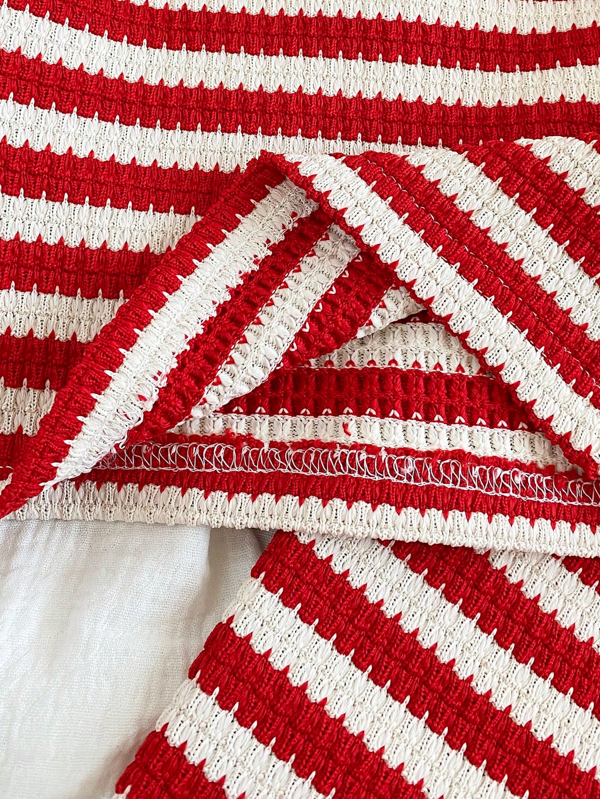 Prenda roja y blanca conjunto para bebe con detalle de costuras y acabado interior