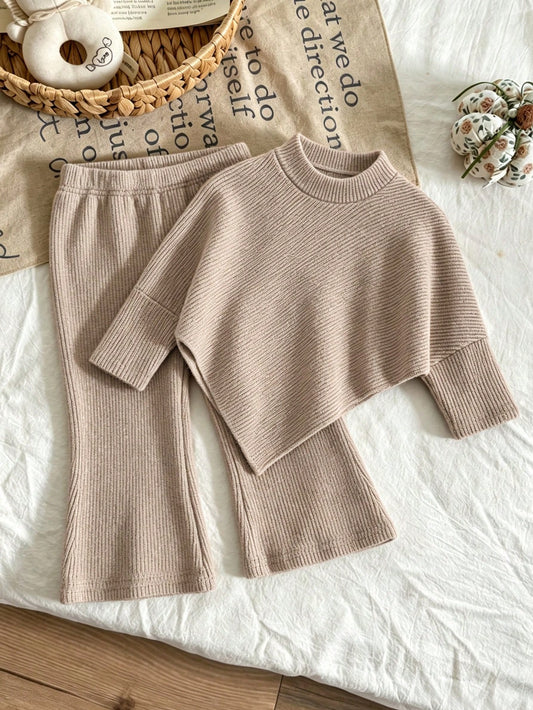 Conjunto caqui de punto acanalado para bebé con suéter asimétrico y pantalón acampanado, vista frontal.