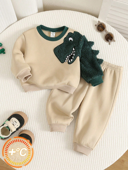Conjunto beige con dinosaurio verde para bebé, sudadera y pantalón, vista frontal.