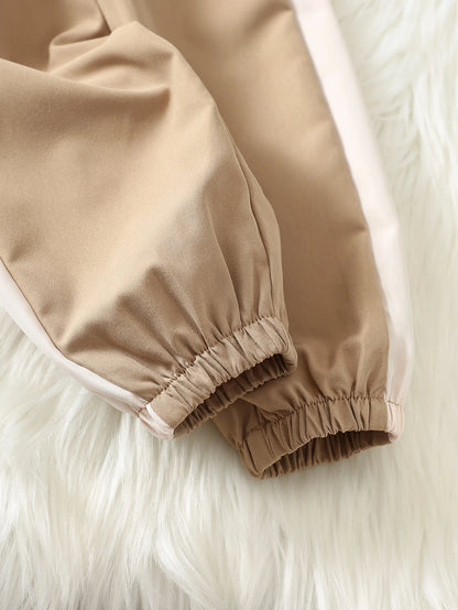 Prenda beige chaqueta deportiva para bebe con detalle de cremallera y elástico