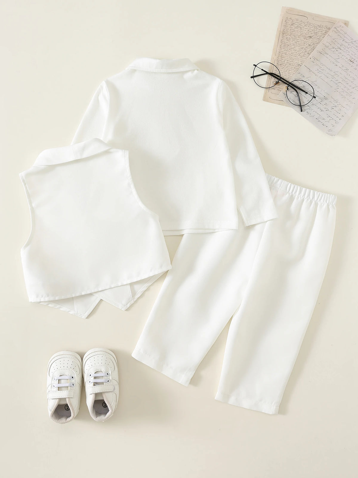 Conjunto blanco de 3 piezas para bebe con camisa de manga larga, chaleco y pantalón, vista trasera.