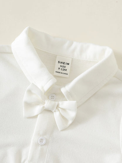 Camisa blanca para bebe con cuello camisero, pajarita decorativa y botones frontales, detalle del acabado.