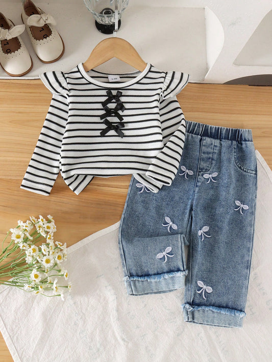 Conjunto blanco a rayas para bebé con jeans azules de lazos bordados, vista frontal.