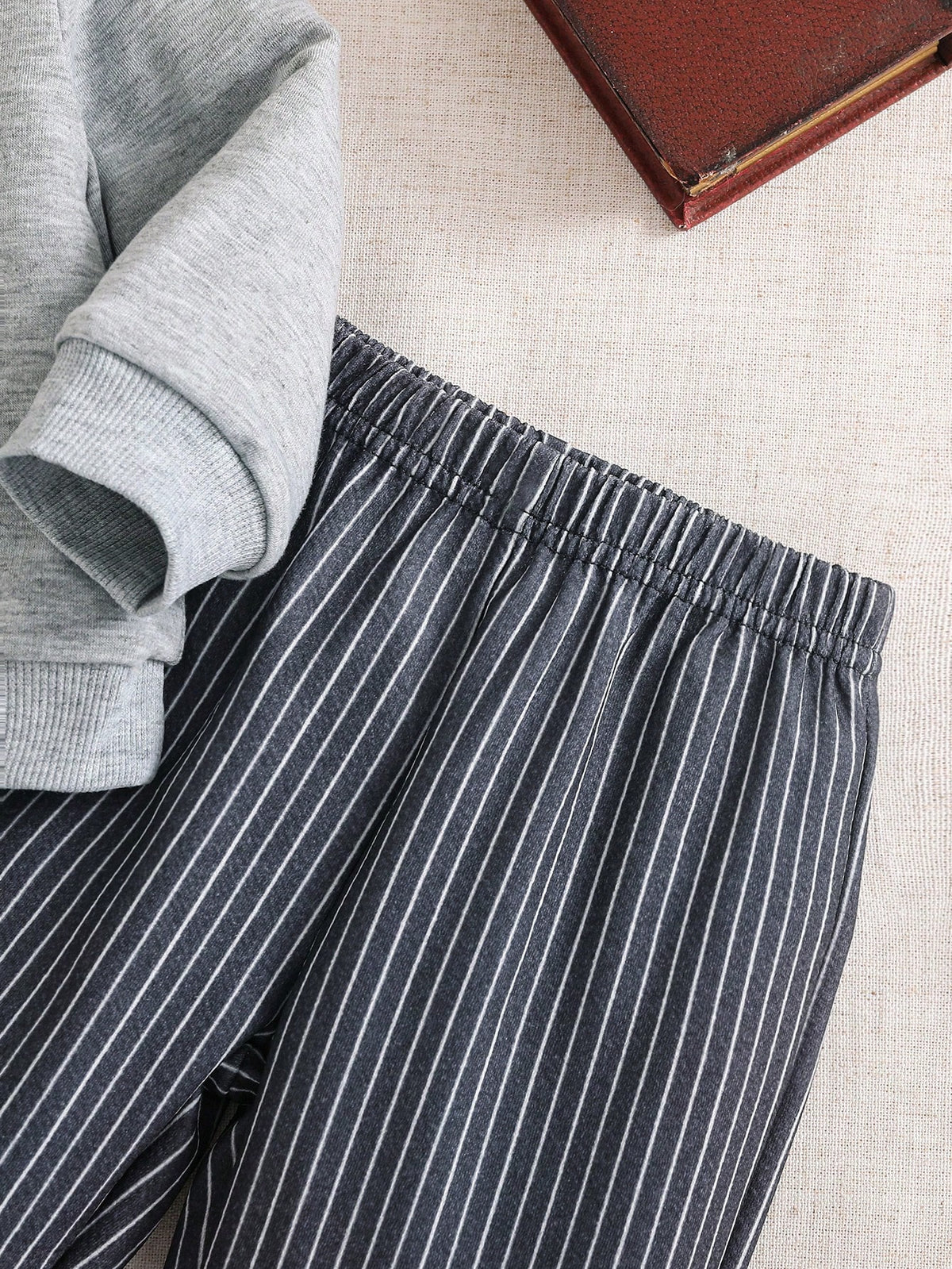 Prenda gris conjunto para bebe con detalle del pantalón a rayas y cintura elástica