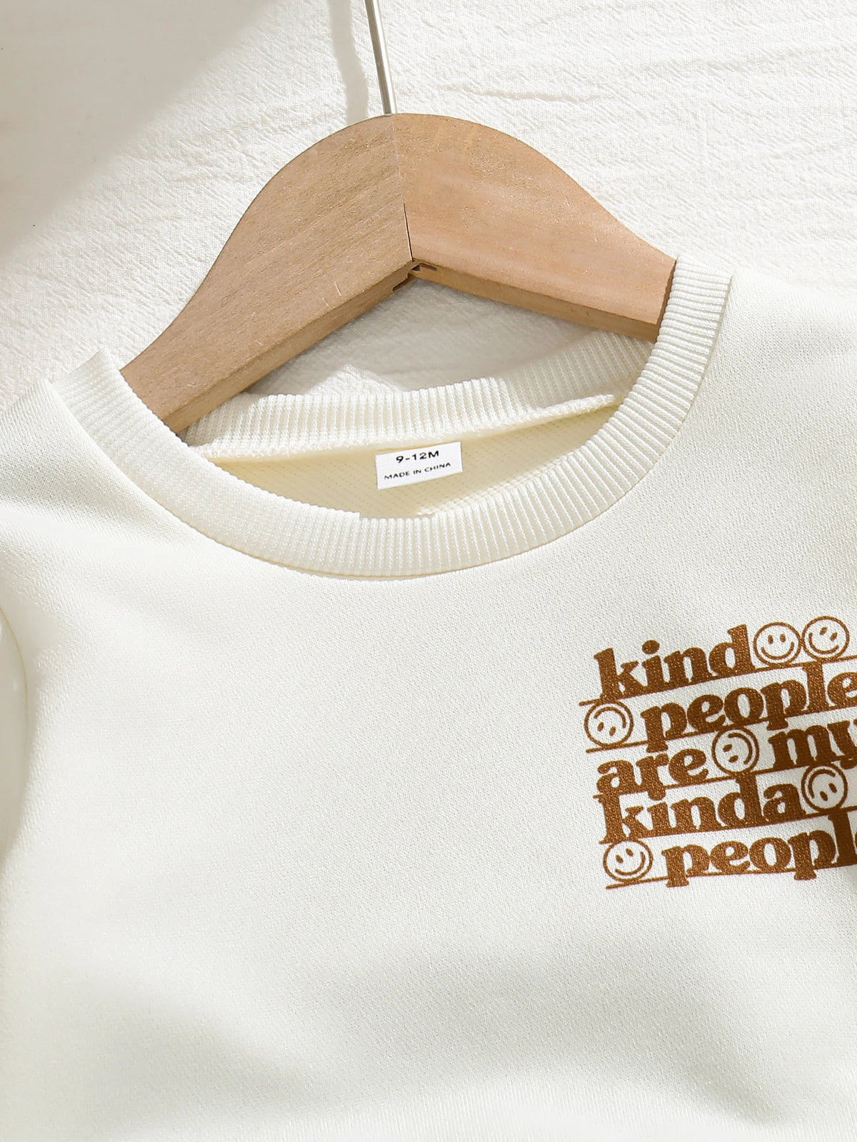 Sudadera crema para bebe con cuello redondo acanalado y estampado de letras marrones