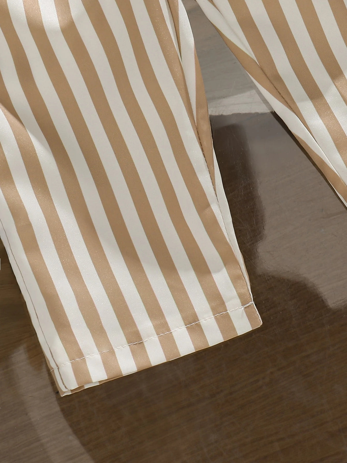 Pantalón beige y blanco a rayas para bebe con detalle del acabado del bajo
