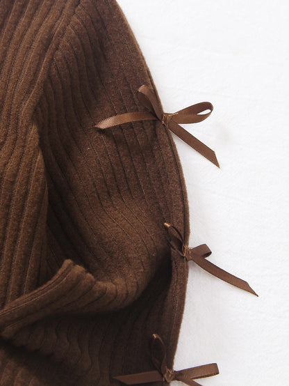 Chaqueta café para bebe con detalle de lazos decorativos en las mangas