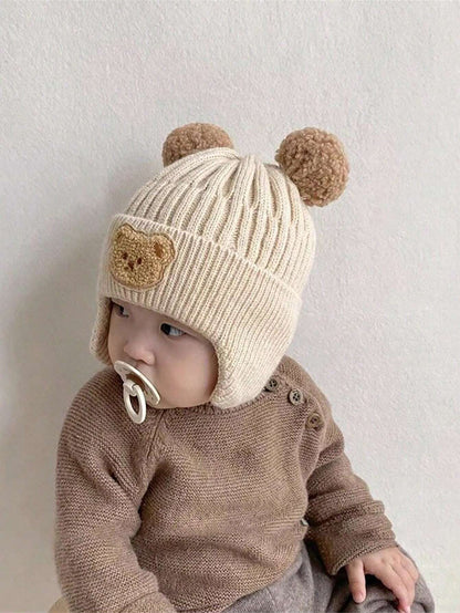 Prenda caqui gorro para bebe con orejeras vista lateral
