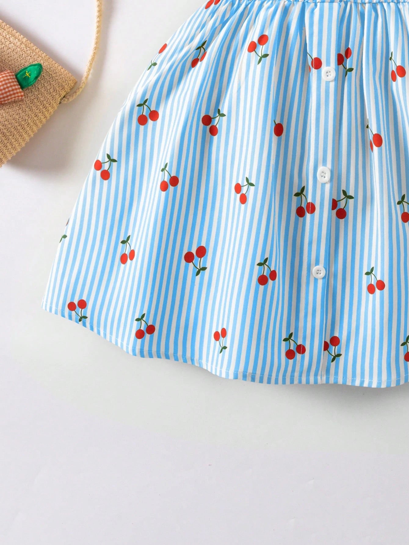 Prenda azul vestido para bebe detalle de estampado de cerezas