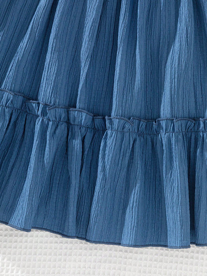 Prenda azul vestido para bebe con detalle de textura y acabado de falda